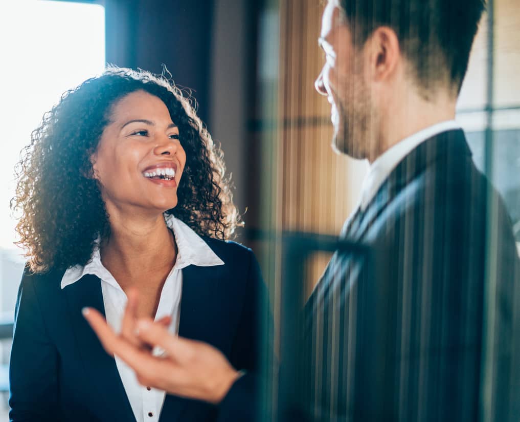 Two employees talking and smiling after a difficult conversation.