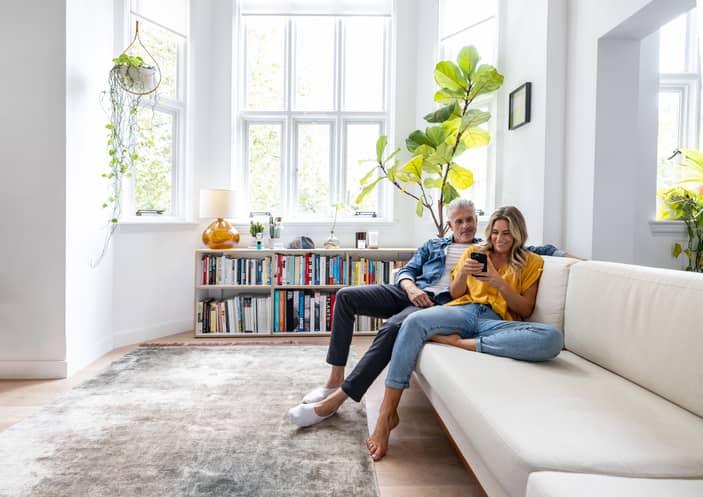 Two pleasers in a relationship happily looking at social media on their cell phone.