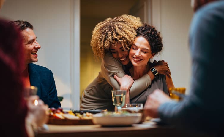 Two-Friends-Hugging-During-A-Dinner-Celebration-1400584574_Compressed