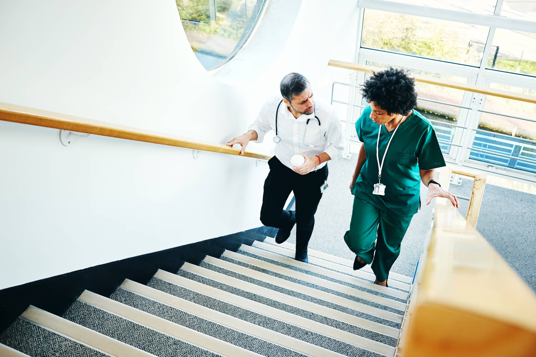 Two doctors walking up a stairs. Autocratic leadership is appropriate in the medical field.