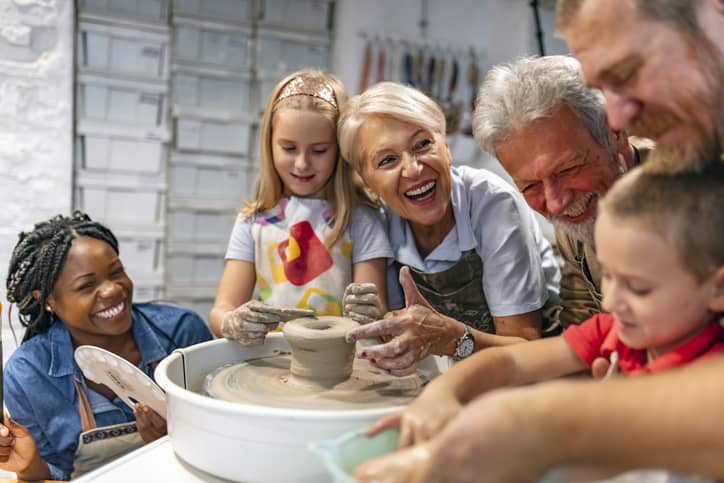 Emotionally intelligent family doing pottery together and laughing.