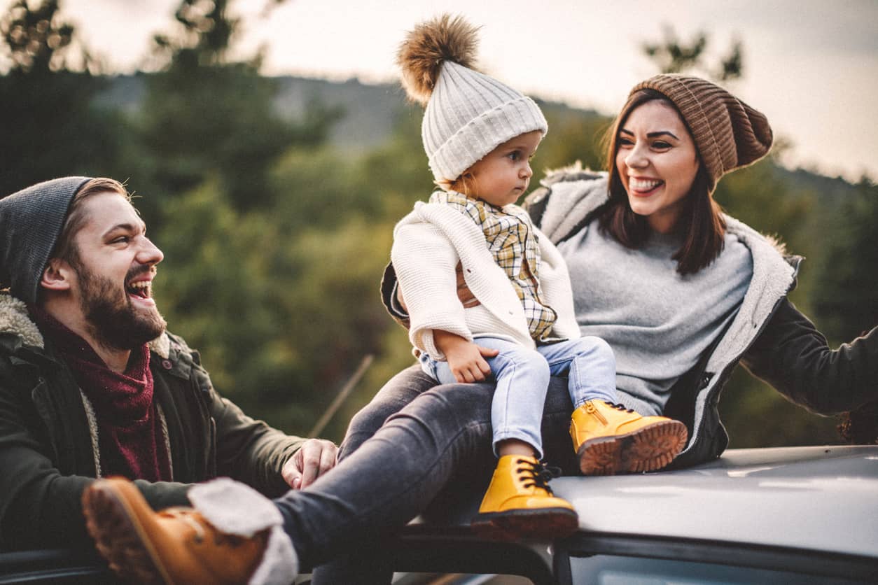 A young couple with a toddler having fun outdoors