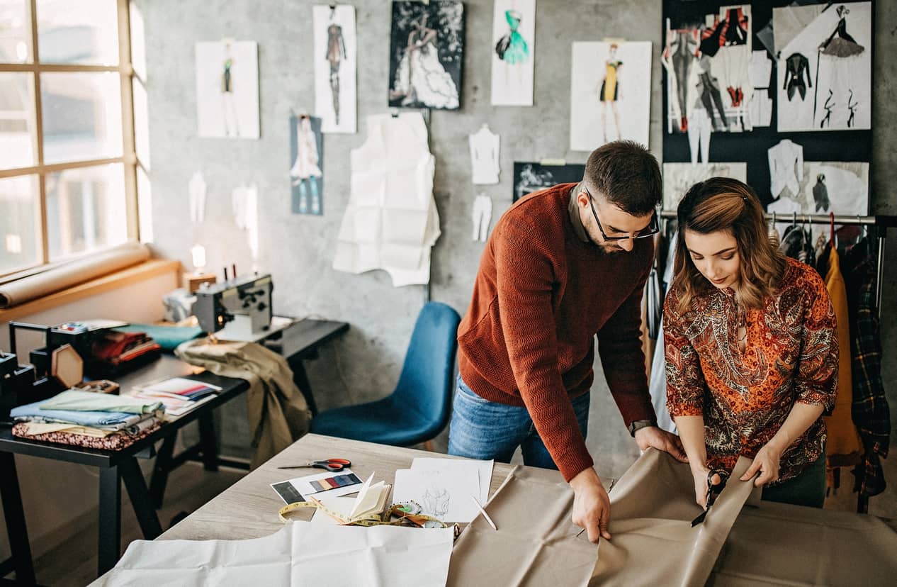 Two clothing designers working together and enjoying their work.