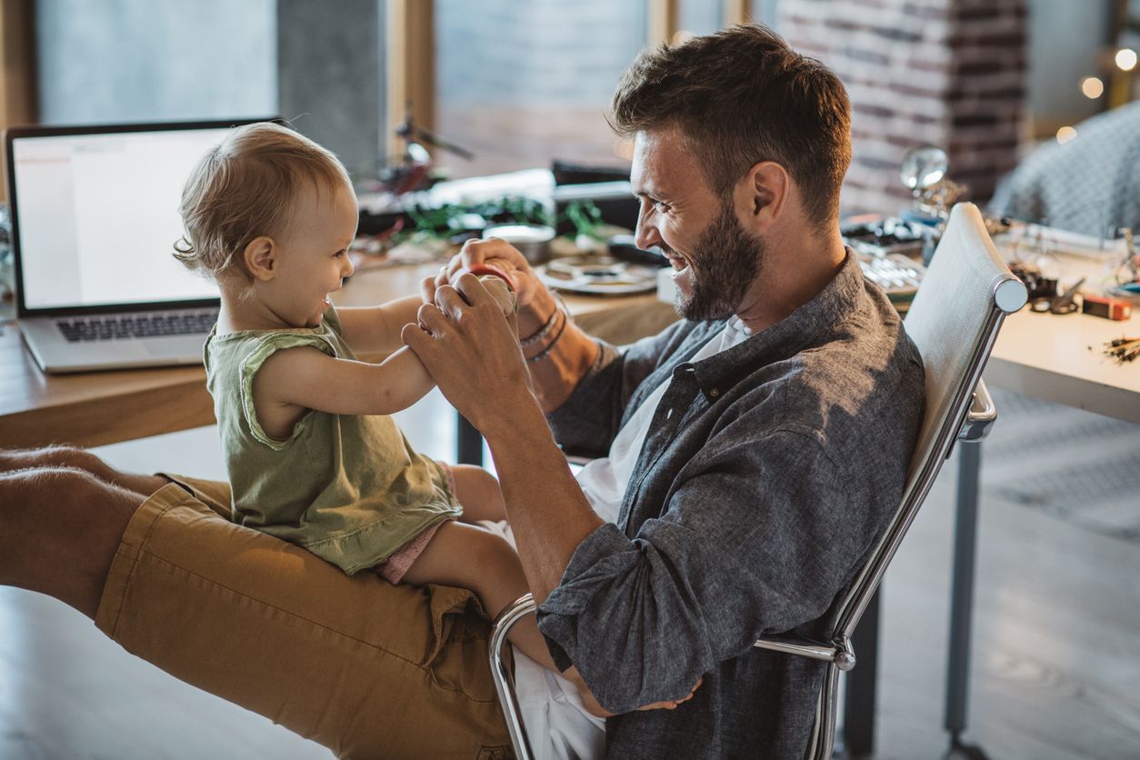 Father playing with his toddler on his lap.