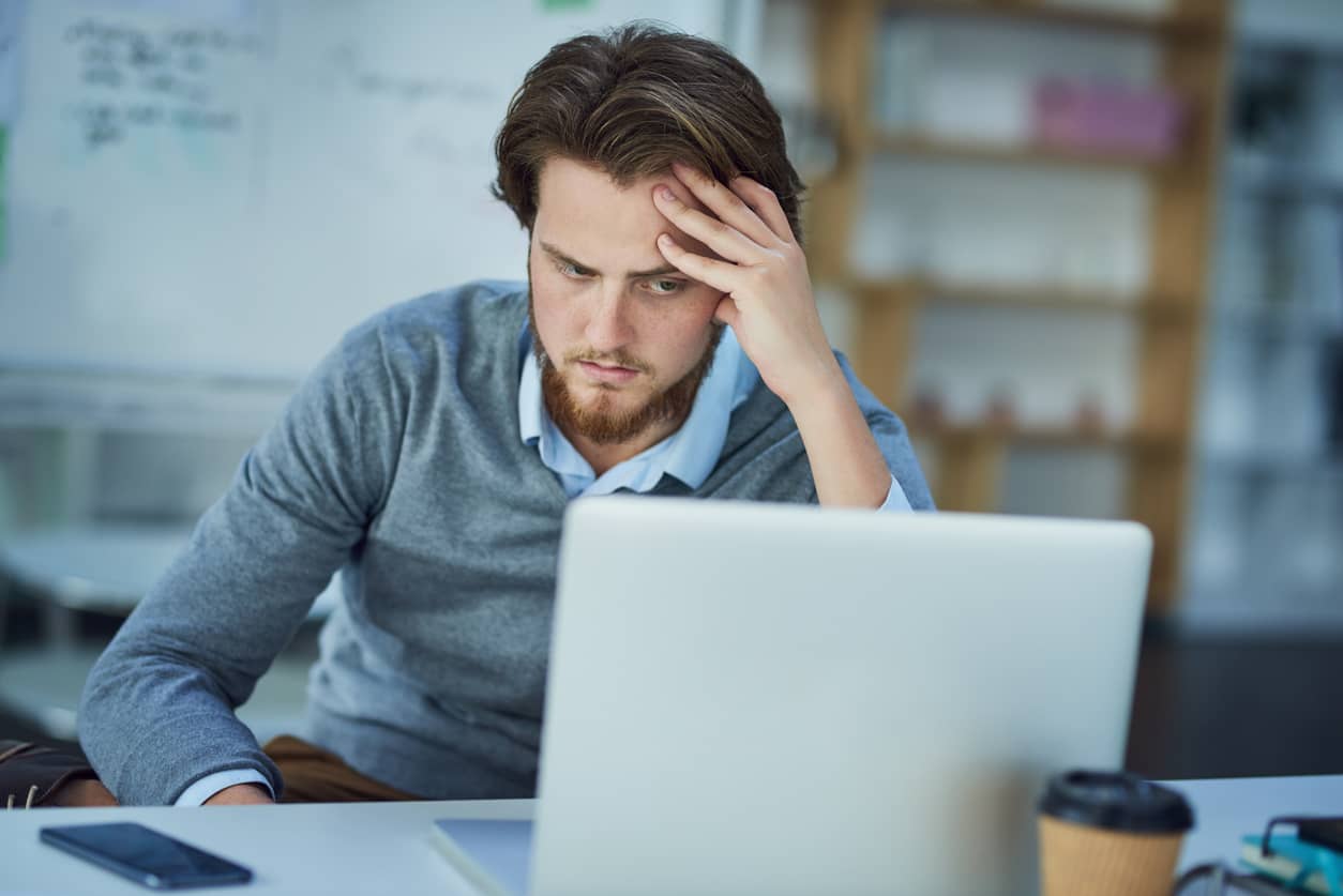 Man upset with himself for procrastinating at work