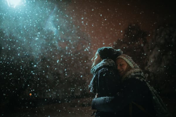 A couple embracing with snow coming down creating a special time of closeness as a couple.