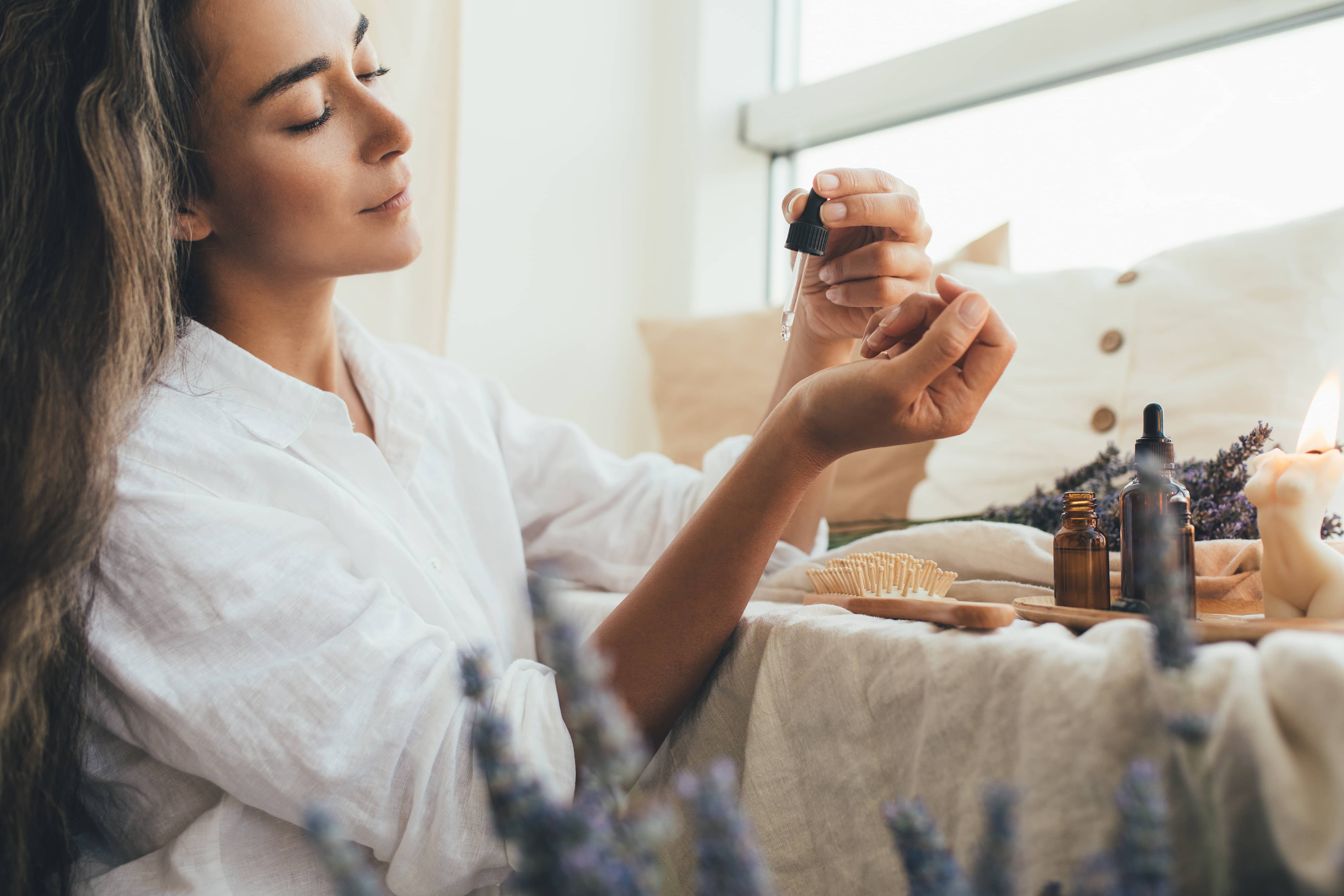 Woman applying essential oil to her wrist to ease anxiety.