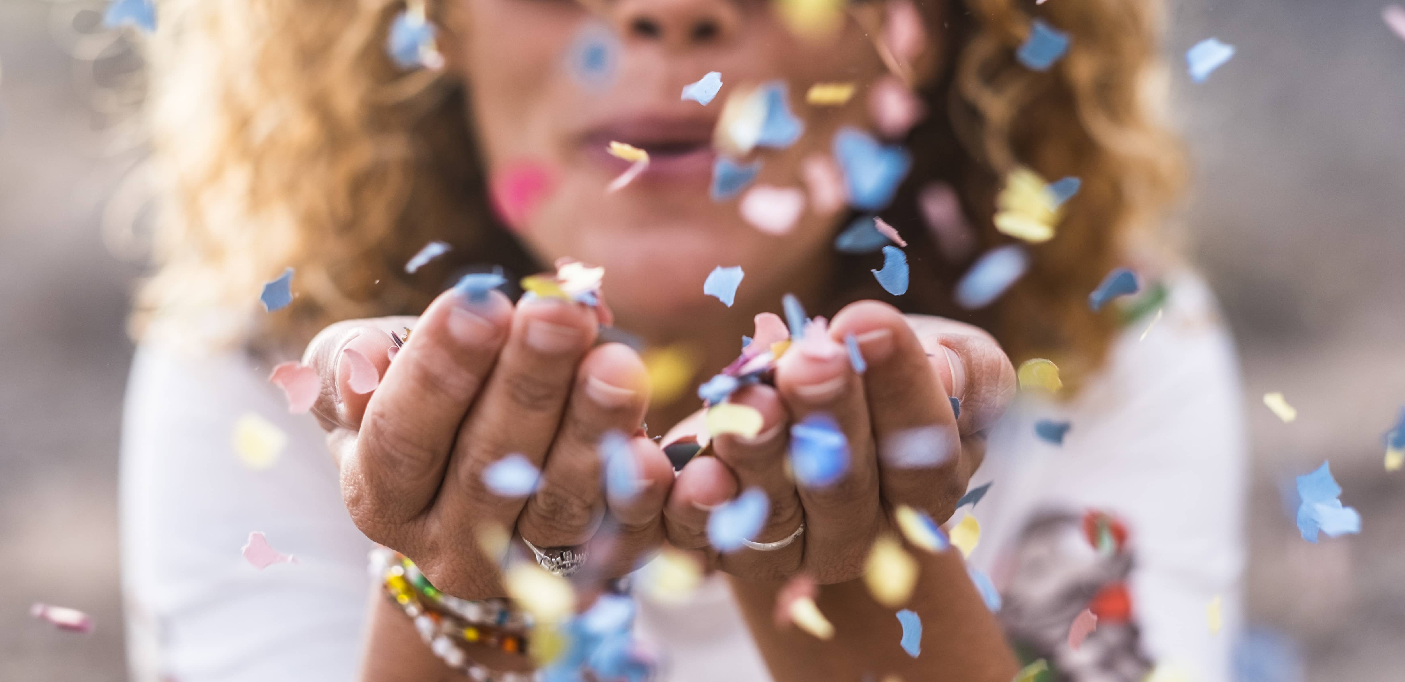 Woman blowing confetti from her hands on New Year's Day!