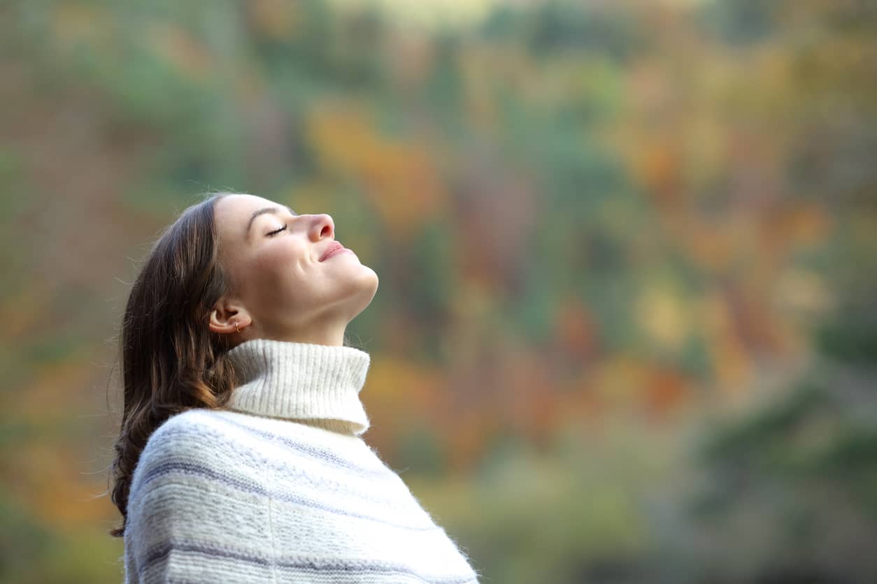 Woman-breathing-fresh-air-in-the-mountain-in-winter-1292470755_Compressed