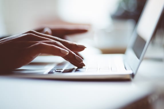 A woman typing out her list for a wedding plan on her MacBook Pro