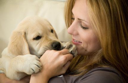 A woman snuggling with her puppy