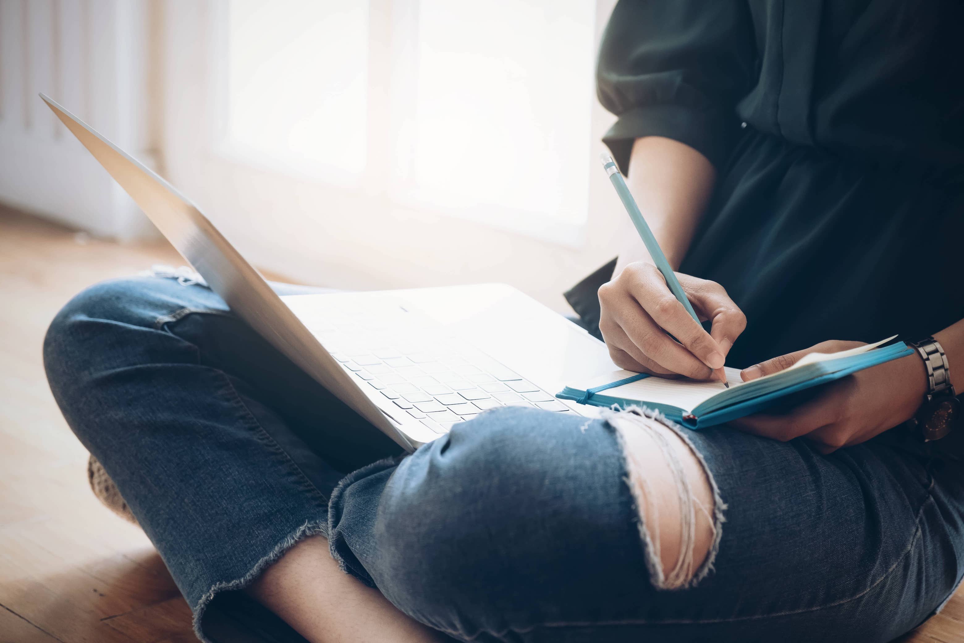 A young woman writing in her gratitude journal.