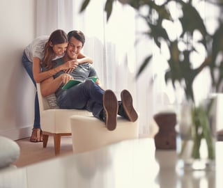 Woman hugging and appreciating her partner while he is reading