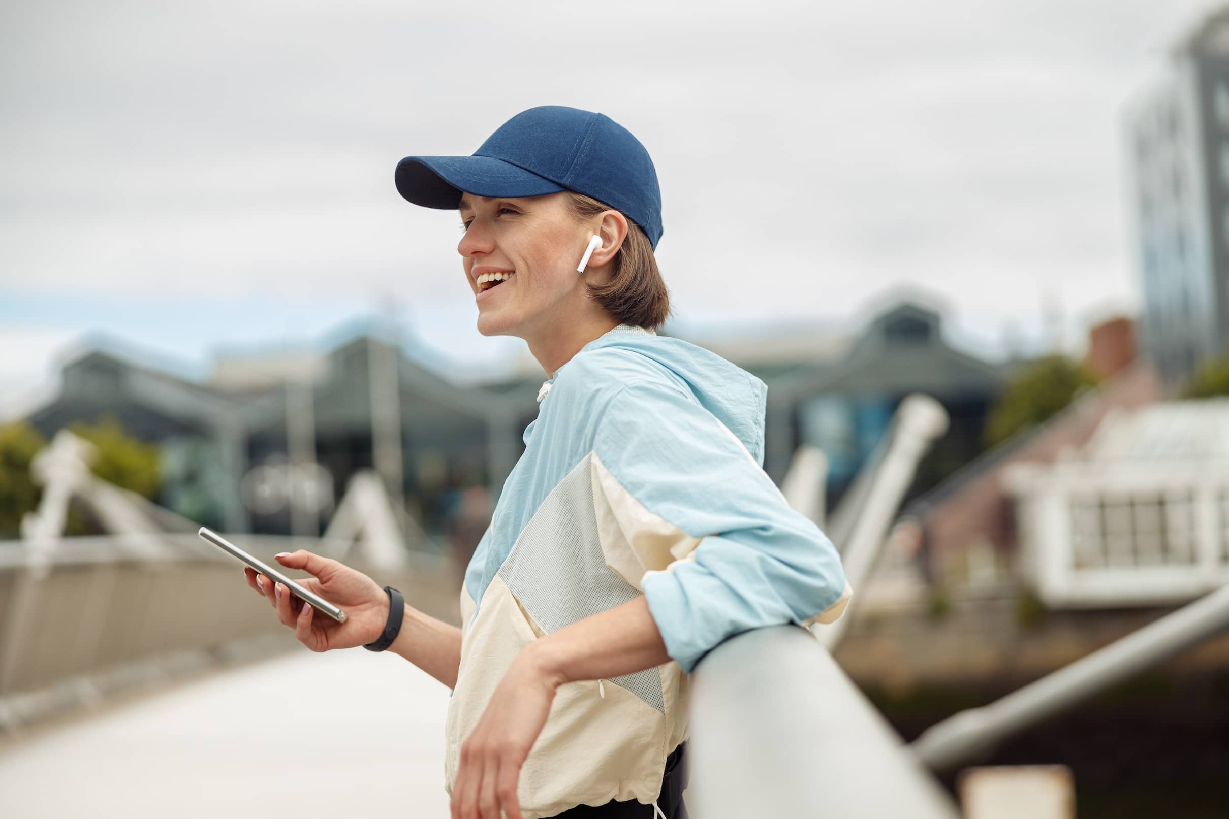 A young, sporty woman using a smartphone during rest after jogging.