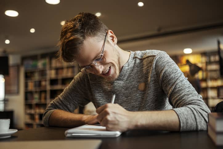 Young man journaling at a desk