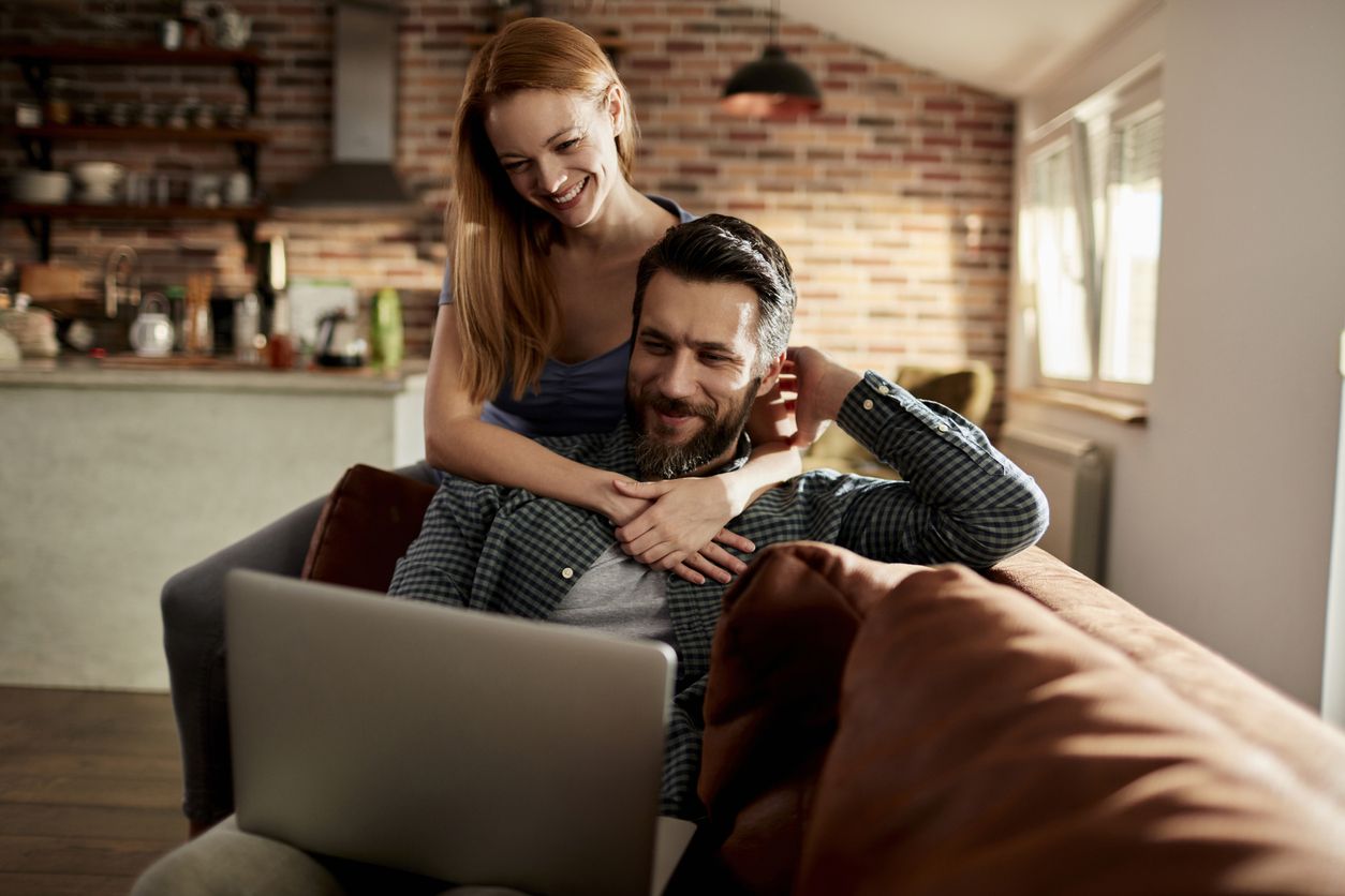 Happy young couple enjoying a YouTube video together