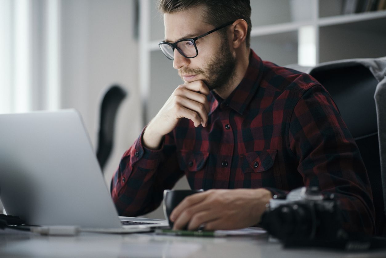 Young entrepreneur on a computer procrastinating an important project.