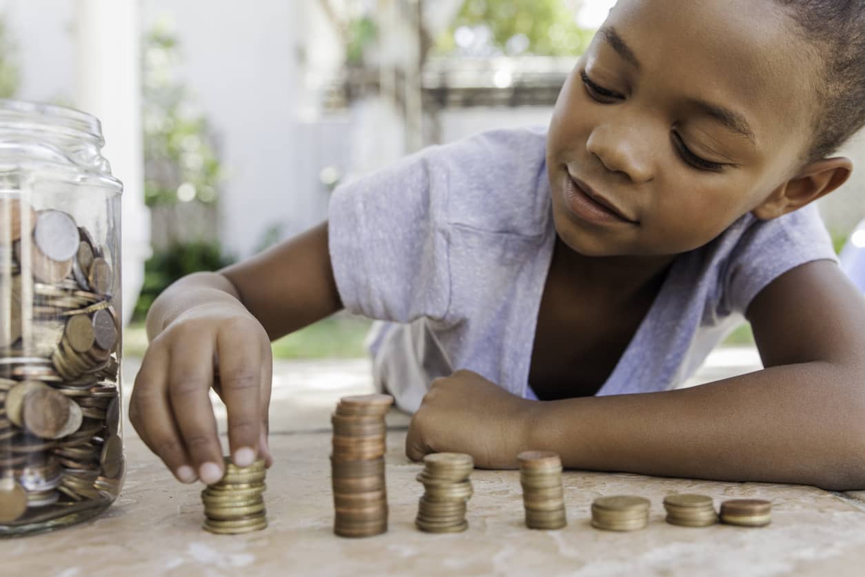 Young girl counting and stacking coins.