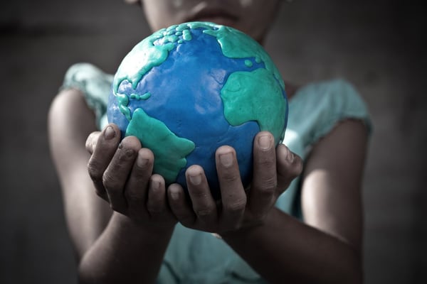 Young girl holding a globe she molded from clay