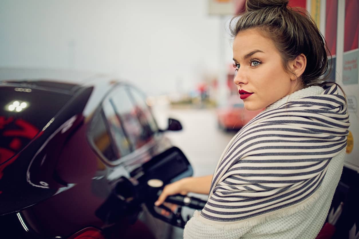 Stressed mompreneur filling her car at a gas station