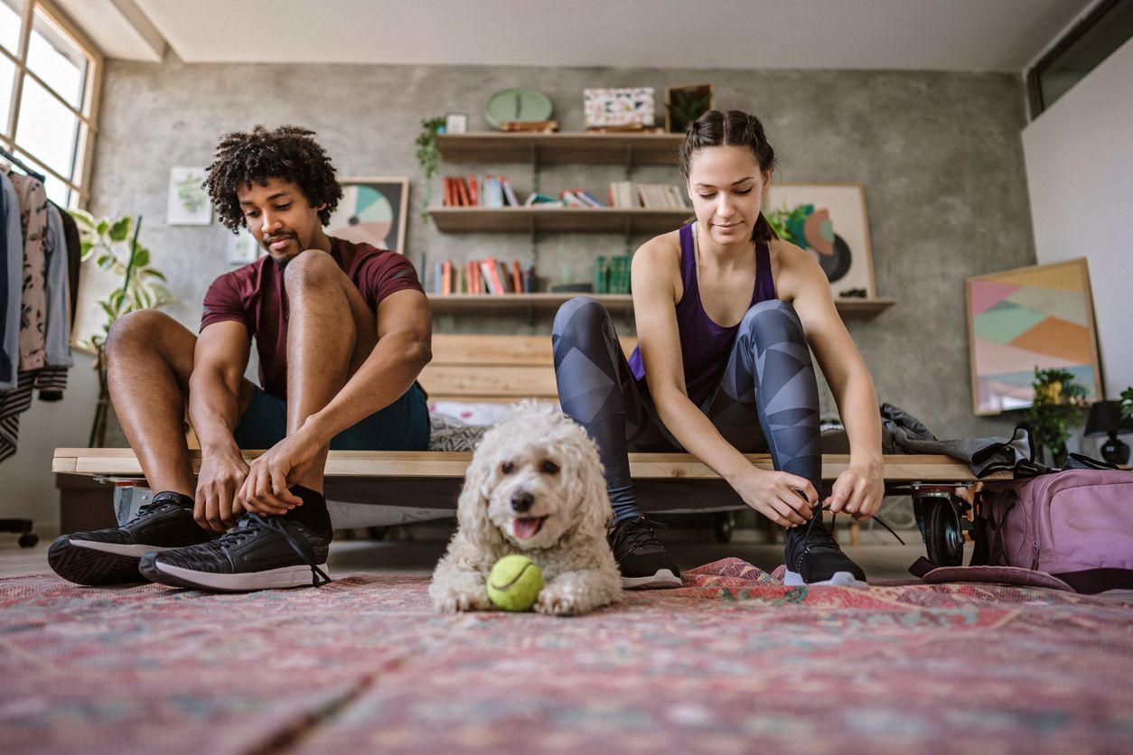 A young multi-ethnic couple preparing for a run together.