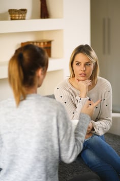 Young woman listening attentively and comforting her friend