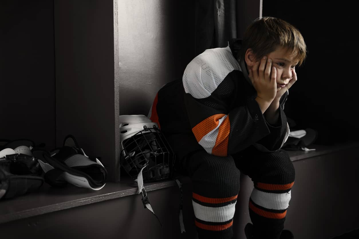 Elementary boy and hockey player in locker room upset about his team's failure to win.