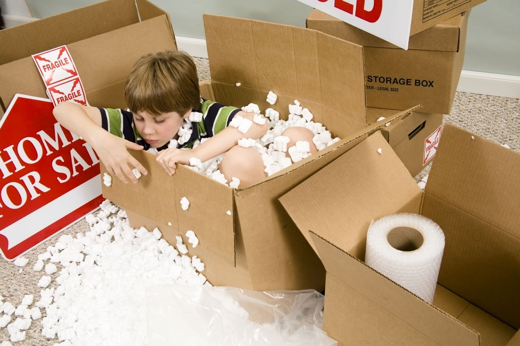 A boy moving box of plastic peanuts