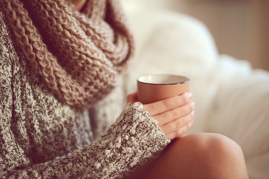 A woman relaxing before bed with a cup of warm turmeric milk.