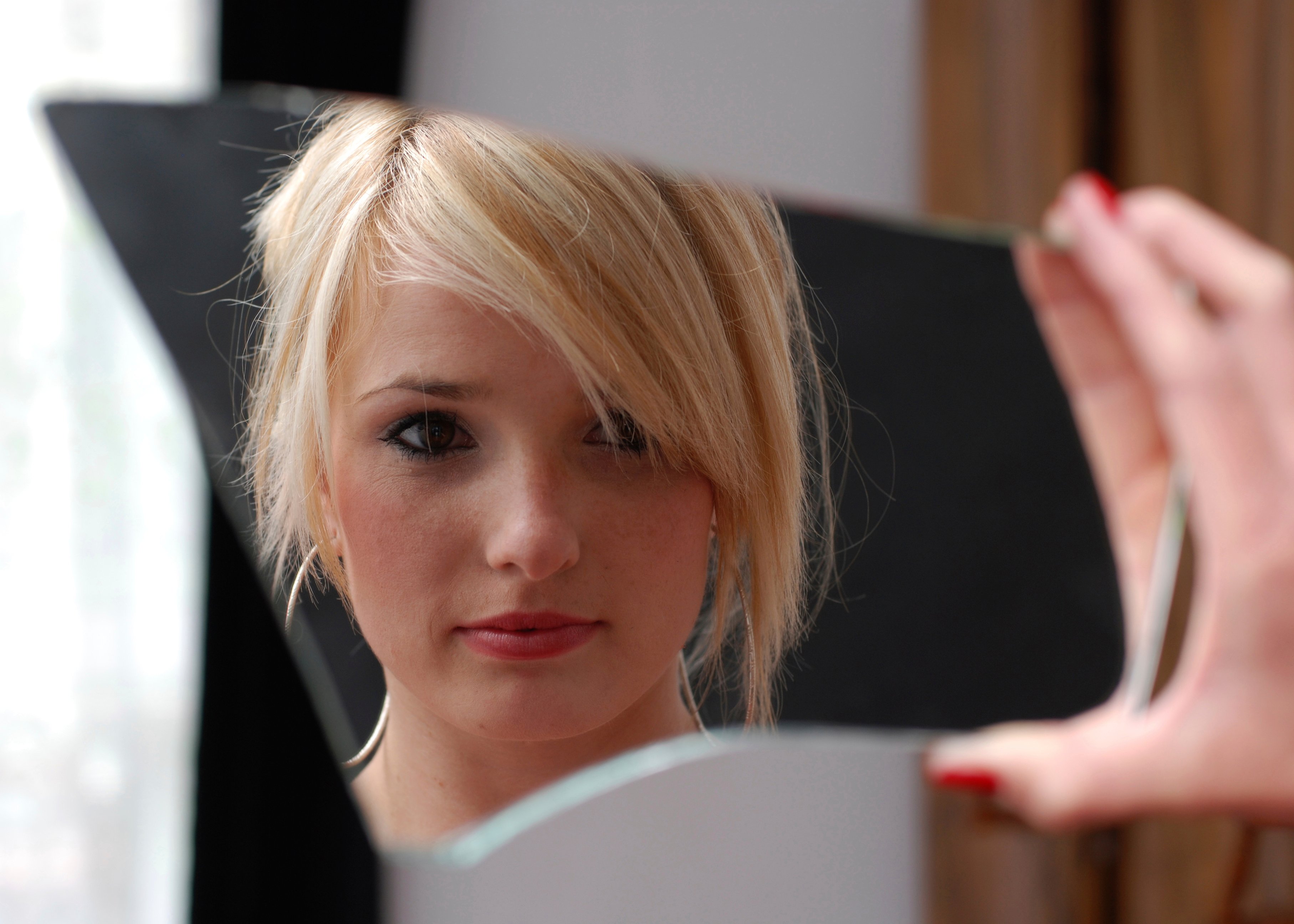 Young girl looking in broken mirro