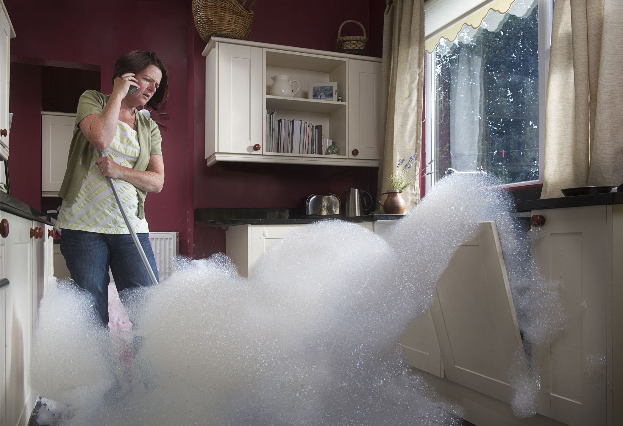 Woman mopping up a kitchen flood; resilience helps ease life's curveballs and challenges