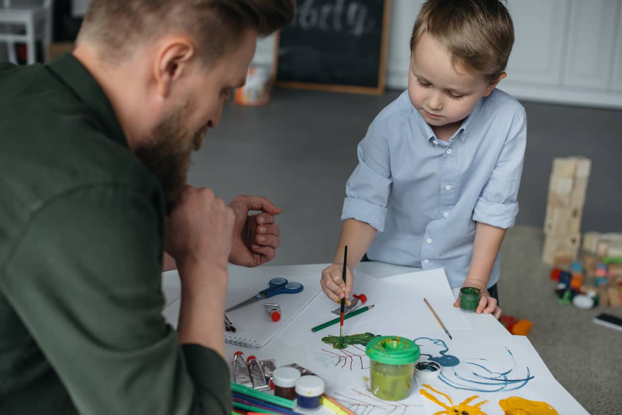 Little boy paining to self-calm with father present