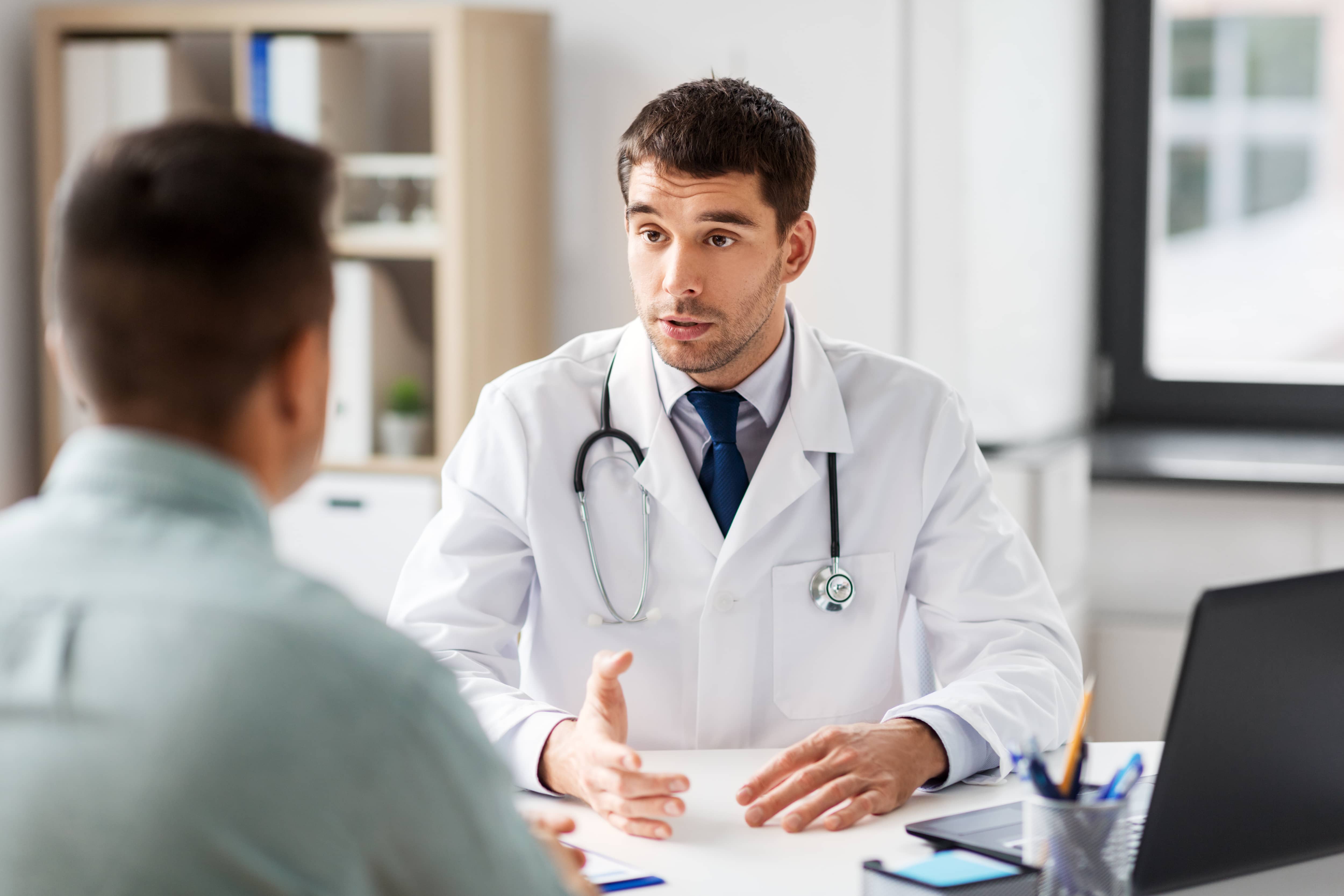 medicine-healthcare-doctor talking to male patient at medical office in hospital_AdobeStock_236268671_Comp