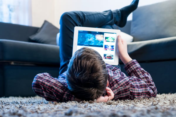 Teenager laying on the floor doing his studies at home