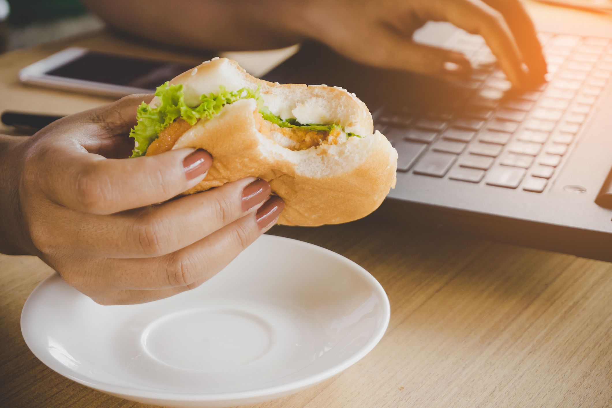 A people pleaser working through lunch at her desk