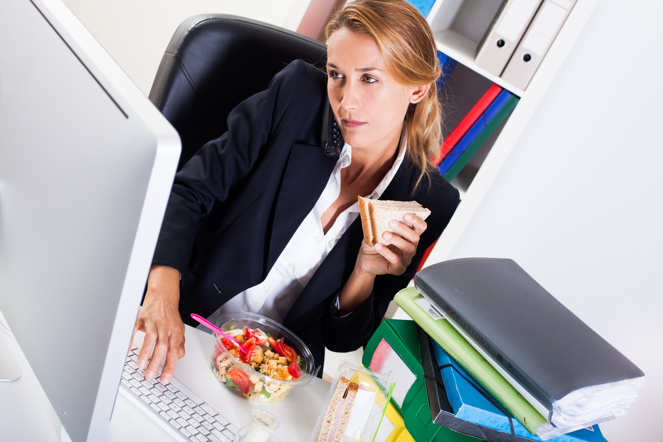 Employee eating lunch and working at her computer