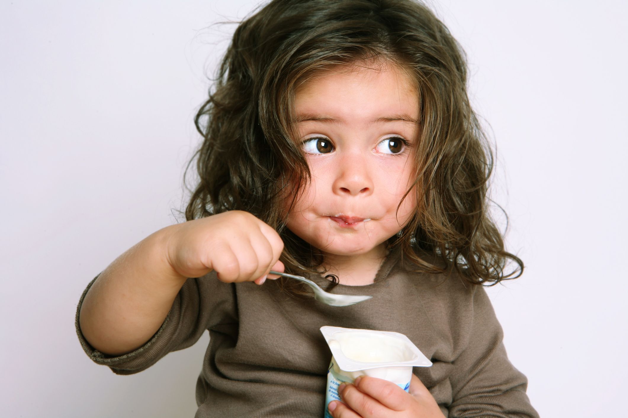 Little girl eating yogurt enthusiastically